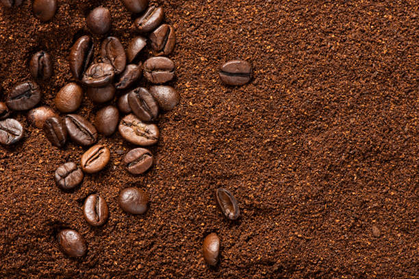 Coffee beans and ground coffee background Some coffee beans over ground coffee for coffee theme backgrounds ground coffee stock pictures, royalty-free photos & images
