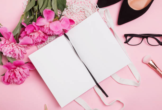 istock Open notepad mock-up on the table with feminine accessories and pink peonies 1163702994