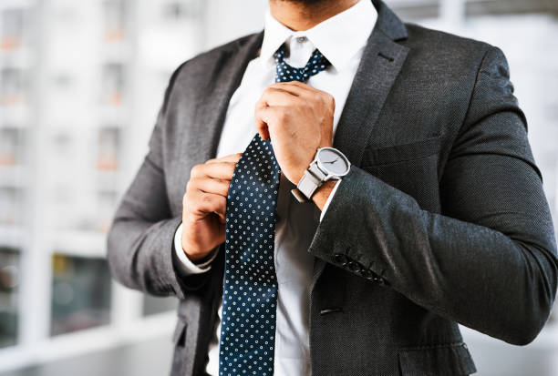 Getting ready to play the business game Closeup shot of a businessman adjusting his tie in an office man adjusting tie stock pictures, royalty-free photos & images
