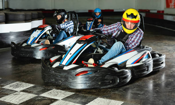 istock Group of people driving go-carts at racing track 1163703242