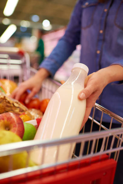 istock Crop woman adding milk into shopping cart 1163703346