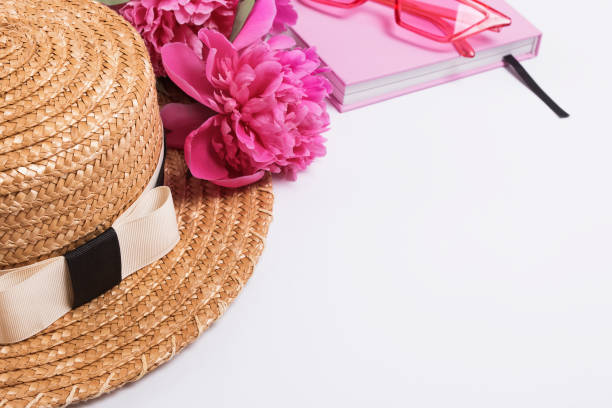 istock Summer straw hat and pink peonies on the white table 1163703405