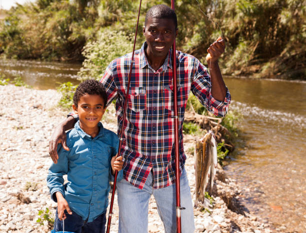 istock Man and boy with fish catch 1163703493