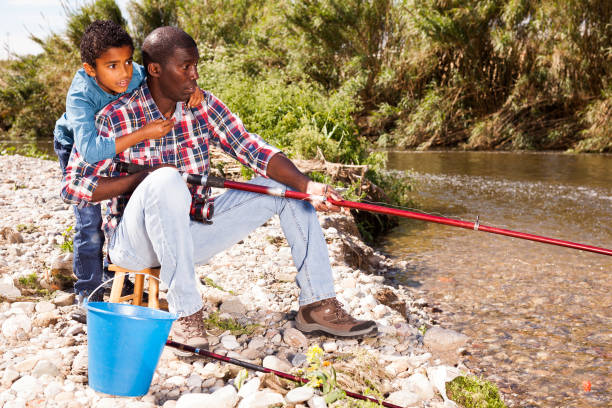 istock Man and boy fishing with rods 1163704066