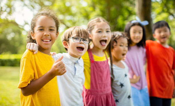 istock Multi-ethnic group of school children laughing and embracing 1163704882