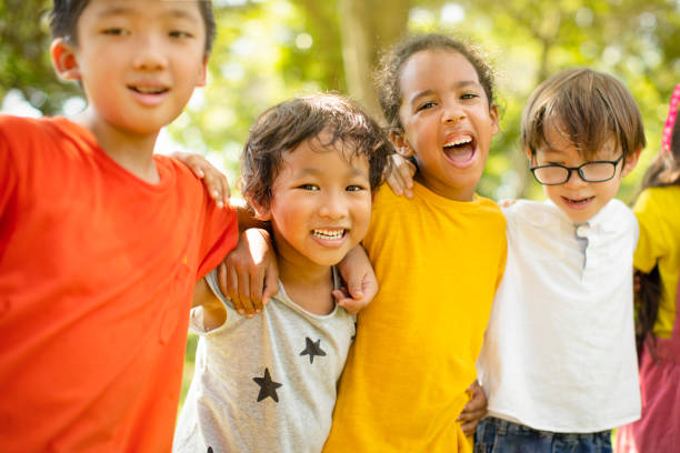 istock Multi-ethnic group of school children laughing and embracing 1163704897