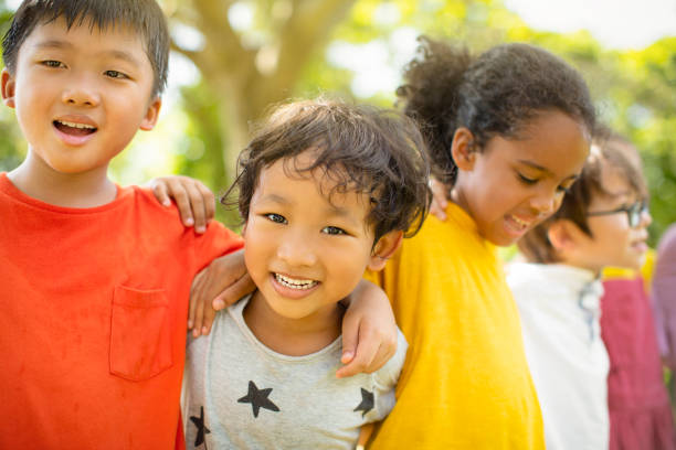 istock Multi-ethnic group of school children laughing and embracing 1163705165