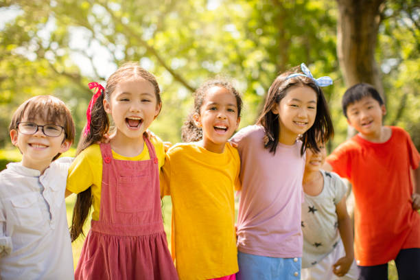 istock Multi-ethnic group of school children laughing and embracing 1163705419