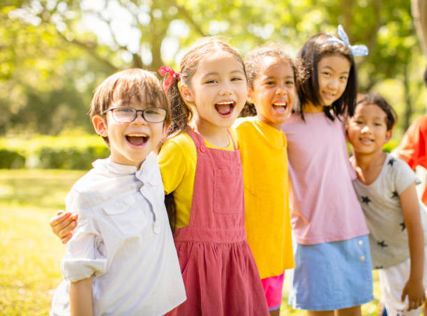 istock Multi-ethnic group of school children laughing and embracing 1163705438