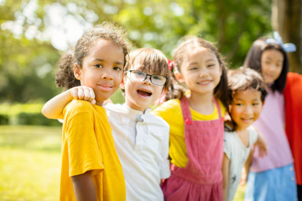 istock Multi-ethnic group of school children laughing and embracing 1163705440