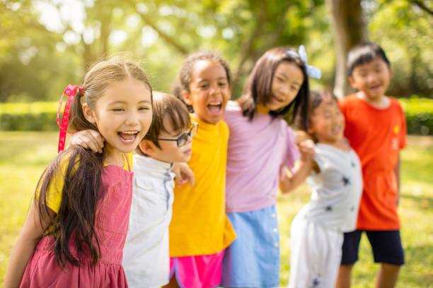 istock Multi-ethnic group of school children laughing and embracing 1163705441