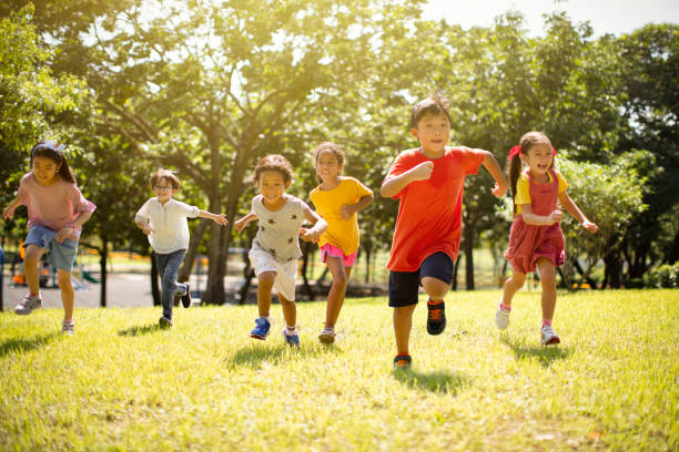 gruppo multietnico di scolari che ridono e corrono - school sports foto e immagini stock