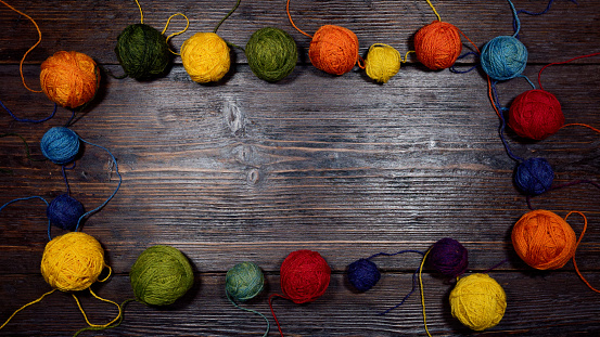 A background with colorful wool balls on the wooden table