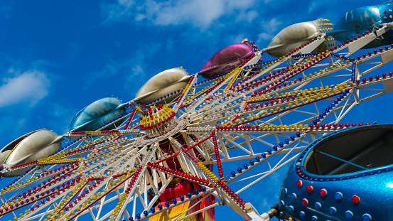The carousel in amusement park, close-up. The Carousel is spinning against the blue sky. Amusement park for children