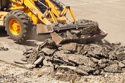 Yellow Excavator Dig The Asphalt With Tractor Bucket Bulldozer Dismantles  Asphalt At Work Stock Photo - Download Image Now - iStock