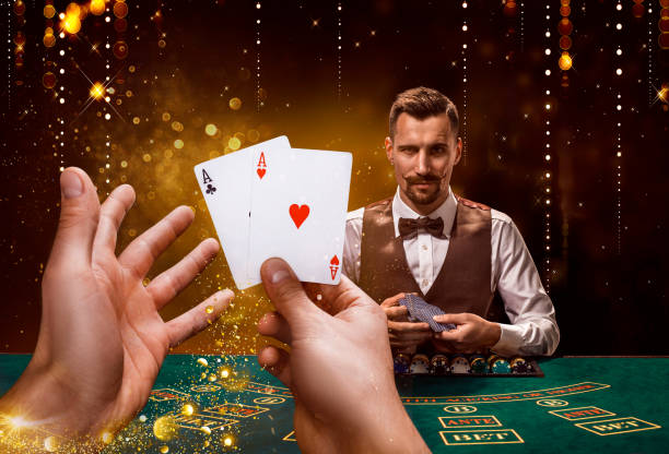 Portrait of a croupier is holding playing cards, gambling chips on table. Black background Portrait of a croupier is holding playing cards, gambling chips on table. Black background. A young male croupier in a shirt, waistcoat and bow tie is waiting for you at the blackjack table poker card game stock pictures, royalty-free photos & images