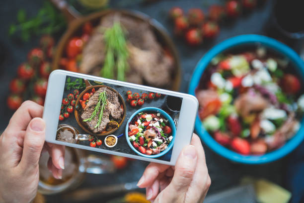 Close-up on a woman taking a photo of the food at a restaurant Sharing food for blog salad bowl photos stock pictures, royalty-free photos & images
