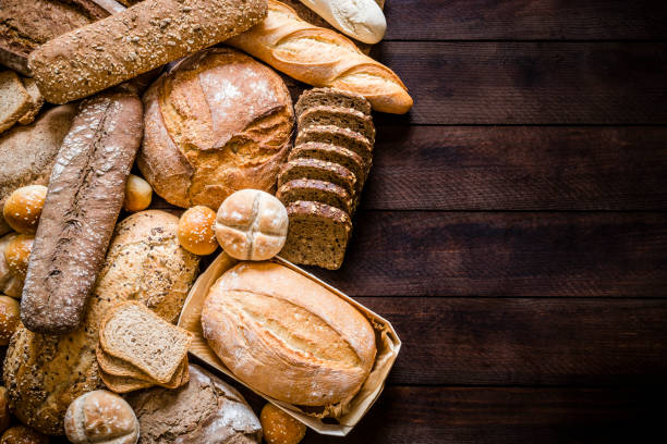 breads assortment with copy space on rustic wooden table - pão fresco imagens e fotografias de stock