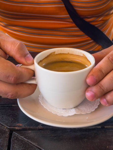 istock Man hands holding cups of coffee on wooden table background 1163707579
