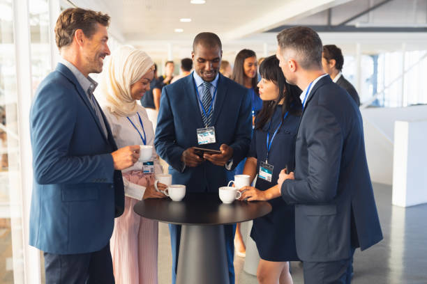 istock Business people interacting with each other while having coffee in office 1163708217
