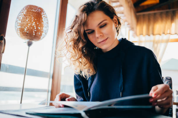 istock Calm smiling young woman sitting at table 1163708791