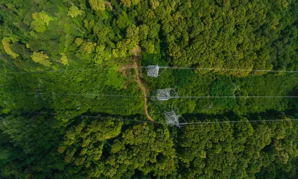 Aerial view. High voltage metal post. High-voltage towers in the forest. Top view.
