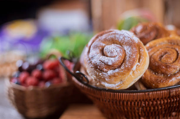 Basket with cinnamon rolls and berries on background selective focus