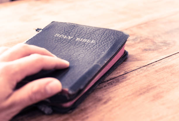 istock Holy Bible isolated on old vintage wooden table 1163712044