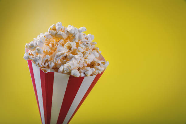 istock striped pop corn bag on yellow background with copy space 1163712138
