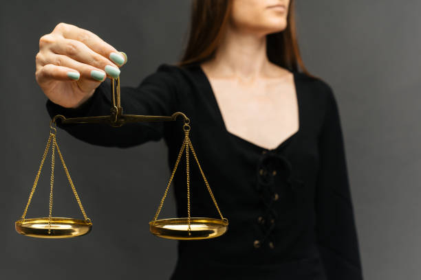 istock Serious woman holding the justice scale on dark background 1163713569