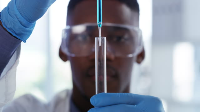 4k video footage of a young male scientist transferring liquid from a pipette to a test tube in a laboratory