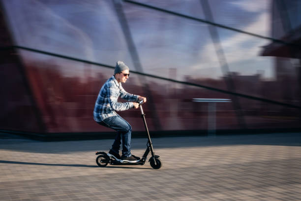 istock Young man on electric scooter on street 1163717981