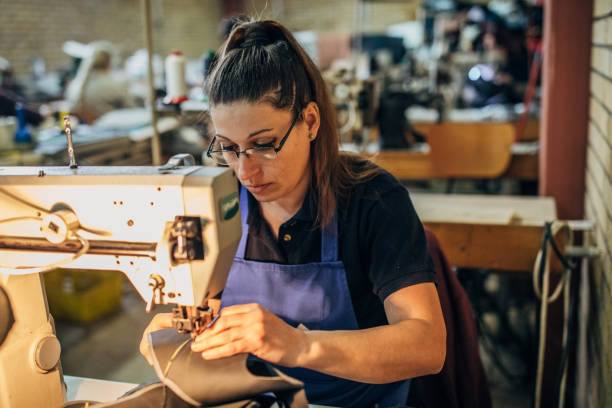 istock Woman working on sewing machine in shoe factory 1163718679
