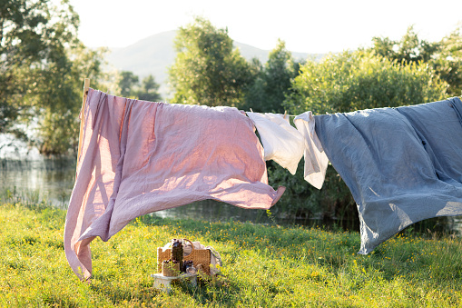 Clean bed sheet hanging on clothesline.