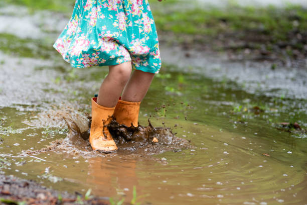 istock Child's feet playing in a puddle 1163719395