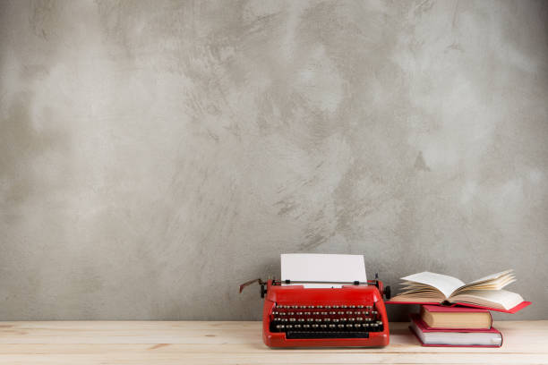 винтажная пишущая машинка и книги на столе с пустой бумагой на деревянном столе - typewriter storytelling fairy tale book стоковые фото и изображения