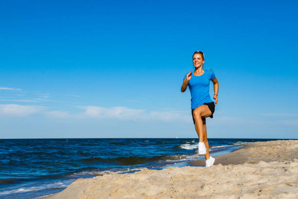 istock Young woman running on beach 1163722445