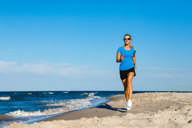 istock Young woman running on beach 1163723066