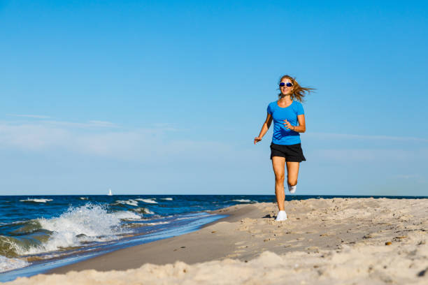istock Young woman running on beach 1163723115