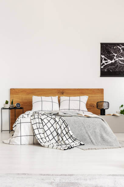 istock Black map on white wall above wooden headboard in simple bedroom interior 1163723176