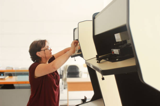 istock Senior Librarian Woman preparing microfilm reader 1163725108