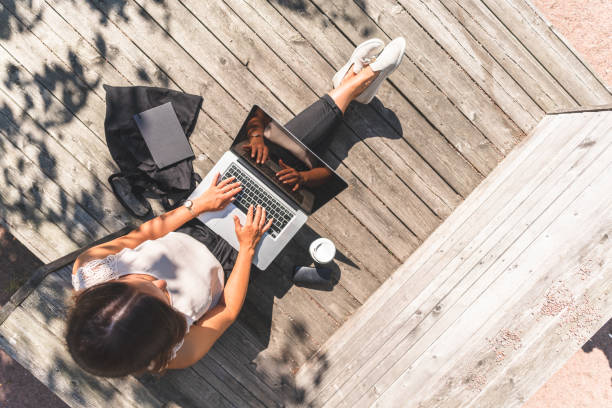 フリーランスの女性は外出先で働いています - outdoors business computer laptop ストックフォトと画像