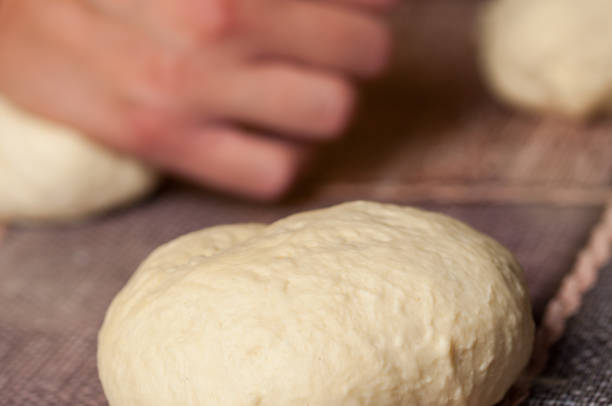 mulher que faz o dought. dought para a pizza e o pão. alimentos. - bread kneading making human hand - fotografias e filmes do acervo