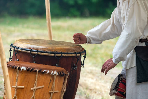 istock Man hands playing leather drum outdoors while wearing rural clothes. Traditional tribal drums performance 1163727264