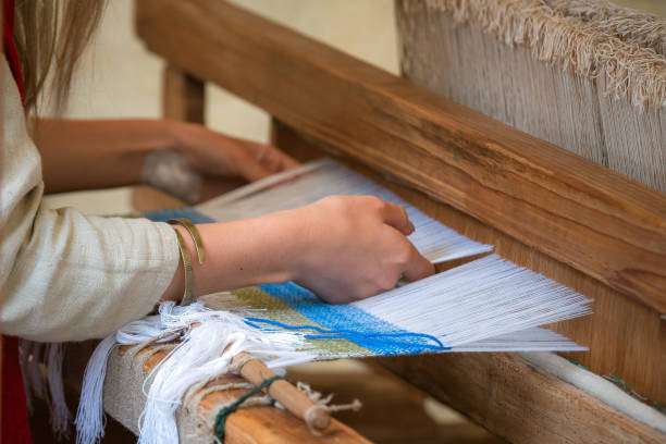 primer plano de las manos de la mujer tejiendo el patrón azul y blanco en el telar. técnica tradicional de tejido - weaving machine fotografías e imágenes de stock