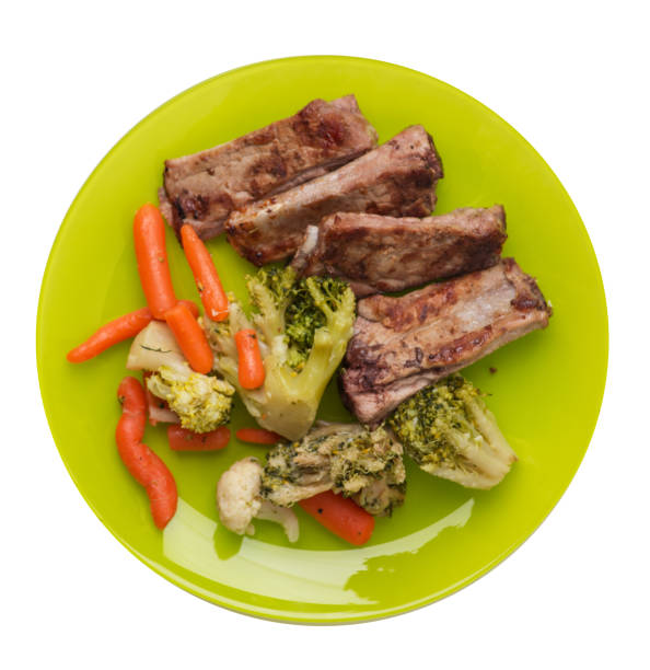 istock grilled pork ribs with broccoli cabbage, carrots and garlic on a plate. fried   ribs with vegetables on a white background. hearty rustic food top view 1163728080
