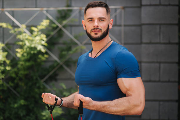 istock Male bodybuilder trains with resistance band. Bearded man working out with elastic band 1163735519