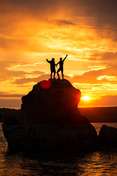 istock Teamwork friendship silhouettes over sea and mountains 1163735880