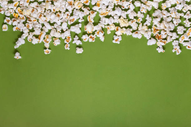 istock White tasty popcorn on a green background. Popcorn pattern on green background. Top view. Copyspace for your text. 1163736704