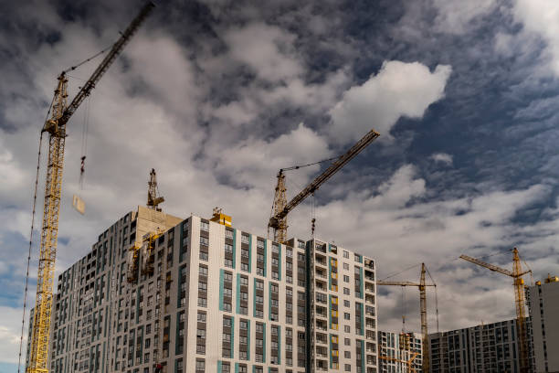 istock The work of construction cranes on the background of flying clouds 1163738429